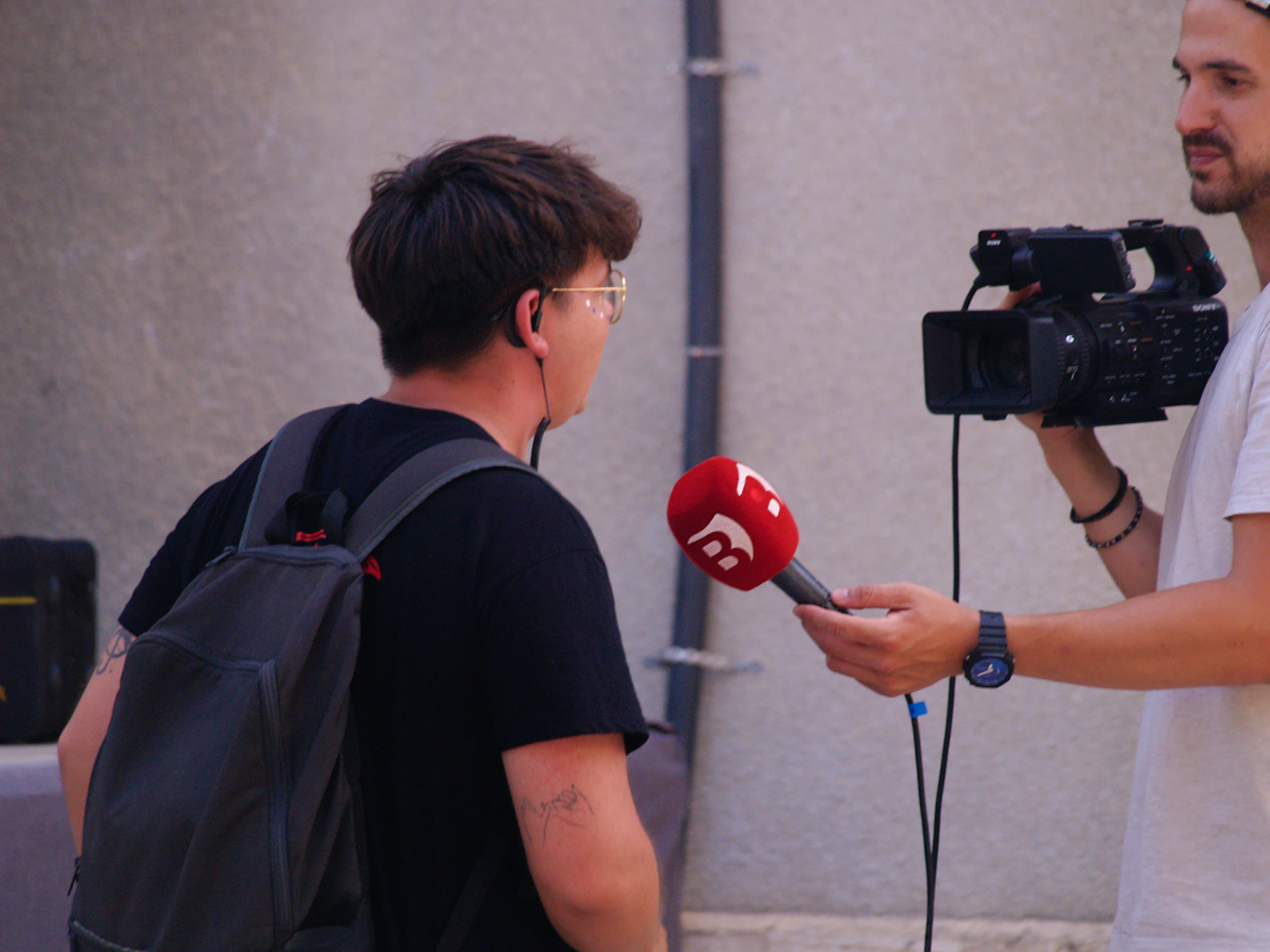 A reporter speaking with a person while a camera records the interview