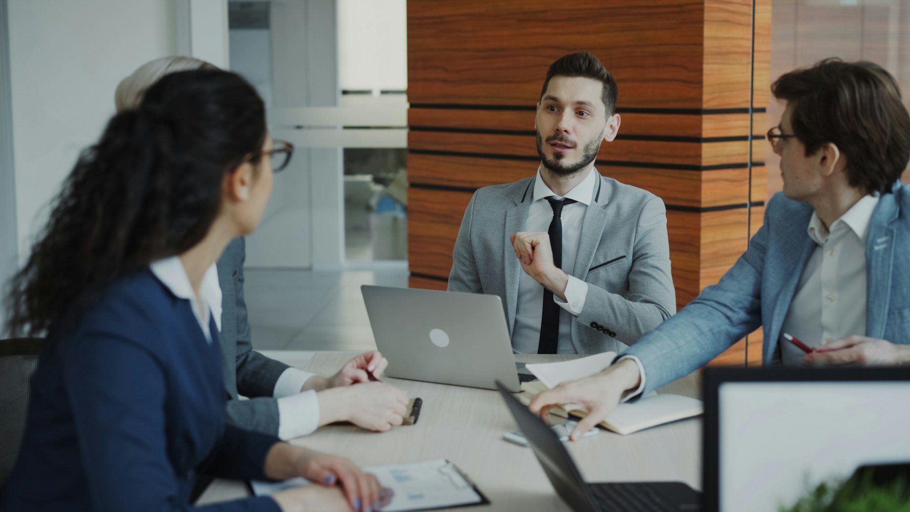 Colleagues in a focused professional discussion around a laptop